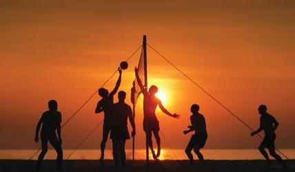 一群人在夕阳下打沙滩排球.